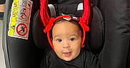 Nelya participe au concours pour gagner de l'argent avec cette photo : baby, car_seat, black_clothing, red_horns, headband, indoor, floor_tiles, child, smiling, cute, infant, person, seat, accessory, happy, looking_at_camera, human, playful, costume, black