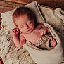 newborn, baby, sleeping, blanket, knitted, basket, wooden_floor, cozy, soft_texture, infant, peaceful, wrapped, cute, child, portrait, relaxing, indoors, warm, resting, small