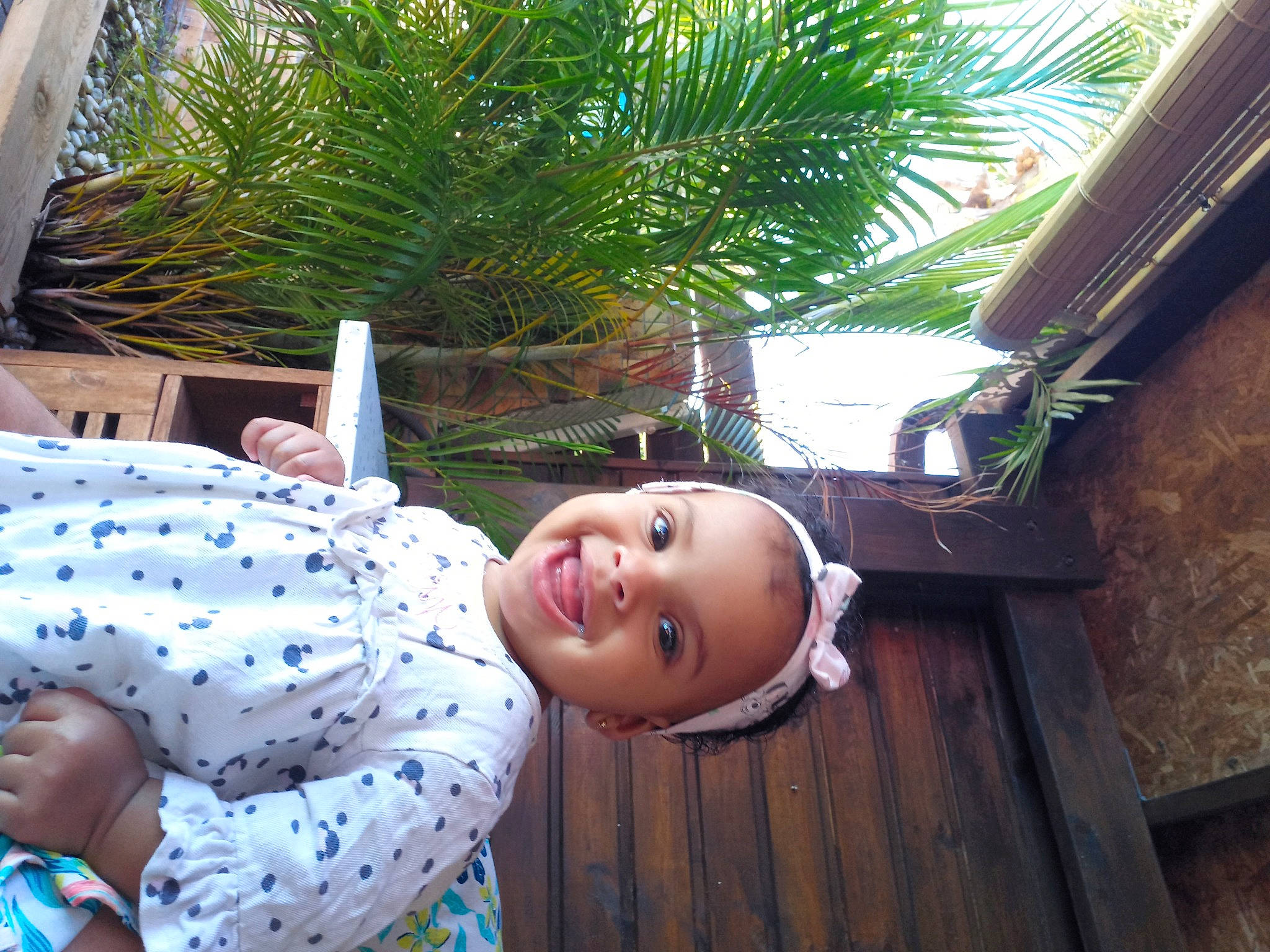 Lia a rejoint le concours — aidez-le/la à gagner de superbes lots ! arecales, baby_laughing, baby_toddler_clothing, child, flooring, fun, grass, happy, house, joy, leaf, leisure, palm_tree, pattern, person, plant, smile, toddler, tree, vacation