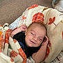 baby, blanket, smiling, sleeping, infant, baby_seat, carpet, cozy, cute, child, soft_texture, indoor, relaxed, peaceful, autumn_colors, face, hands, wearing_clothes, comfort, resting