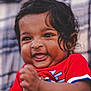 baby, child, clapping, red_shirt, curly_hair, face, smile, happy, portrait, closeup, infant, cute, young_child, skin, person, cheerful, outdoor, blurred_background, expression, toddler