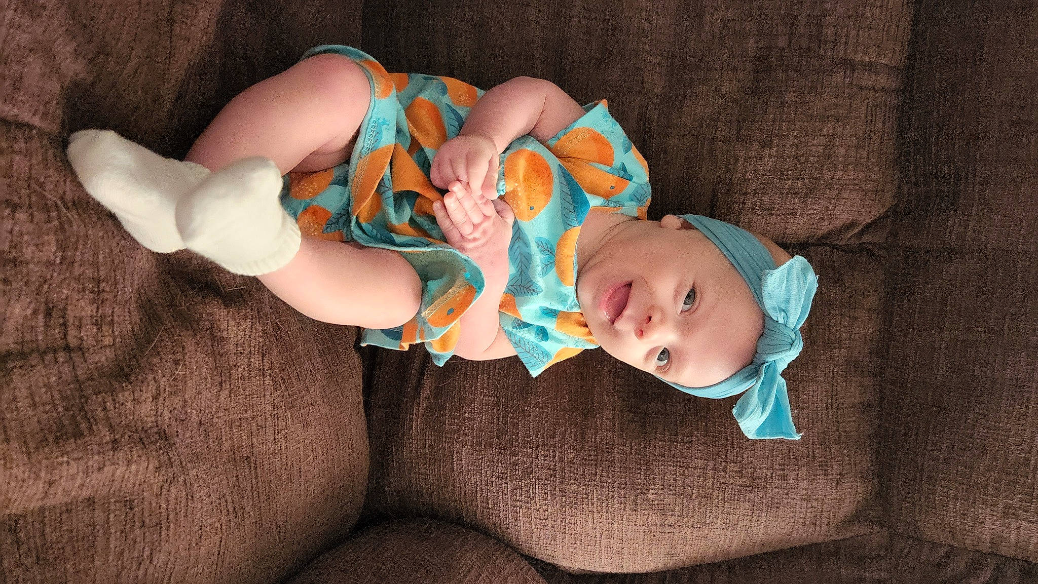 Collins is registered to the contest to win money with this photo: baby, baby_toddler_clothing, child, comfort, eye, finger, fun, hand, head, headgear, headwear, human_body, knee, leg, nail, person, skin, smile, textile, thigh