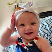Leila joined the competition — help win amazing prizes! apparel, baby, blanket, blue, child, clothing, cute, face, hand, happy, headband, indoors, infant, pattern, person, portrait, red, smile, toddler, white
