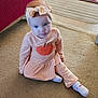 baby, bow, carpet, child, couch, curious_expression, cute, face, floor, furniture, headband, home, indoor, long_sleeve, pants, peach_outfit, person, rug, sitting, socks
