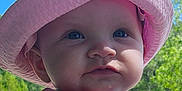 Leila is registered to the contest to win money with this photo: baby, background, blue_eyes, child, colorful_clothing, cute, daylight, face, hat, nature, outdoor, people, person, pink_hat, portrait, skin, striped_clothing, summer, sunny, trees