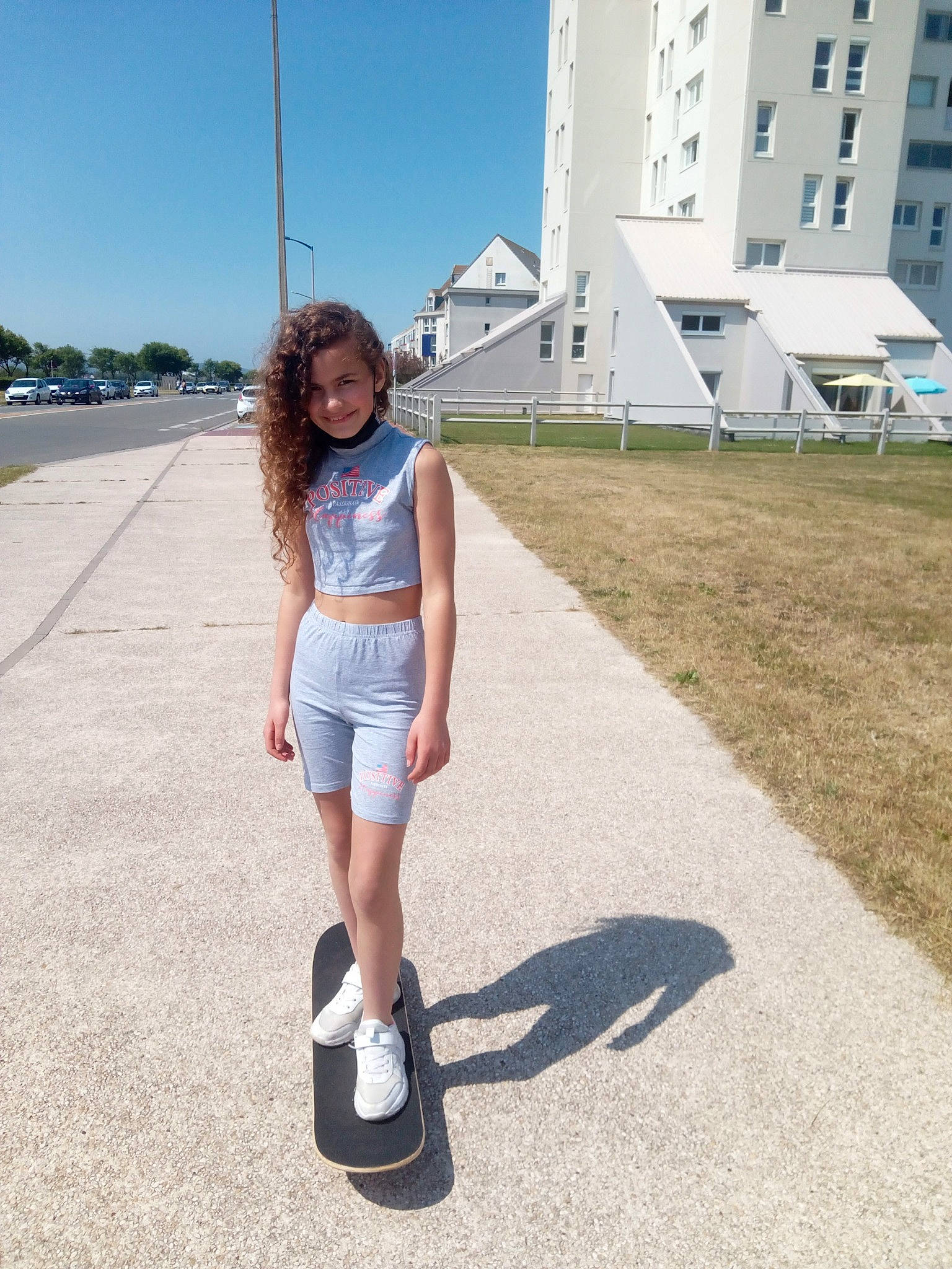 Angie participe au concours pour gagner de l'argent avec cette photo : asphalt, blond, building, denim, dress, electric_blue, fun, grass, human_leg, joy, knee, leisure, person, plant, road, road_surface, rolling, shorts, sky, thigh