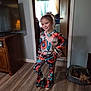Kaitlyn is registered to the contest to win money with this photo: child, girl, smiling, pose, colorful_clothing, floral_pattern, indoor, wooden_floor, dog, pet_bed, curtains, television, cabinet, door, home, person, happy, flooring, casual, portrait
