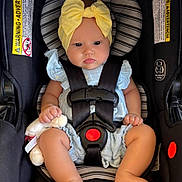 Amelia joined the competition — help win amazing prizes! baby, infant, car_seat, yellow_bow, plush_toy, stripes, seatbelt, clothing, cute, child, sitting, hands, legs, foot, headband, soft_toy, safety_harness, portrait, indoors, child_seat