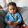 Messiah joined the competition — help win amazing prizes! baby, child, infant, portrait, sitting, chair, cushion, blue_outfit, gray_chair, curly_hair, brown_skin, wide_eyes, serious_expression, indoor, home, lamp, curtains, safety_harness, teething_ring, toy