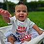 Zayden is registered to the contest to win money with this photo: baby, child, smiling, happy, outdoor, grass, basket, white_clothing, shorts, sneakers, face, hand, portrait, mohawk, cute, infant, summer, nature, playful, patriotic
