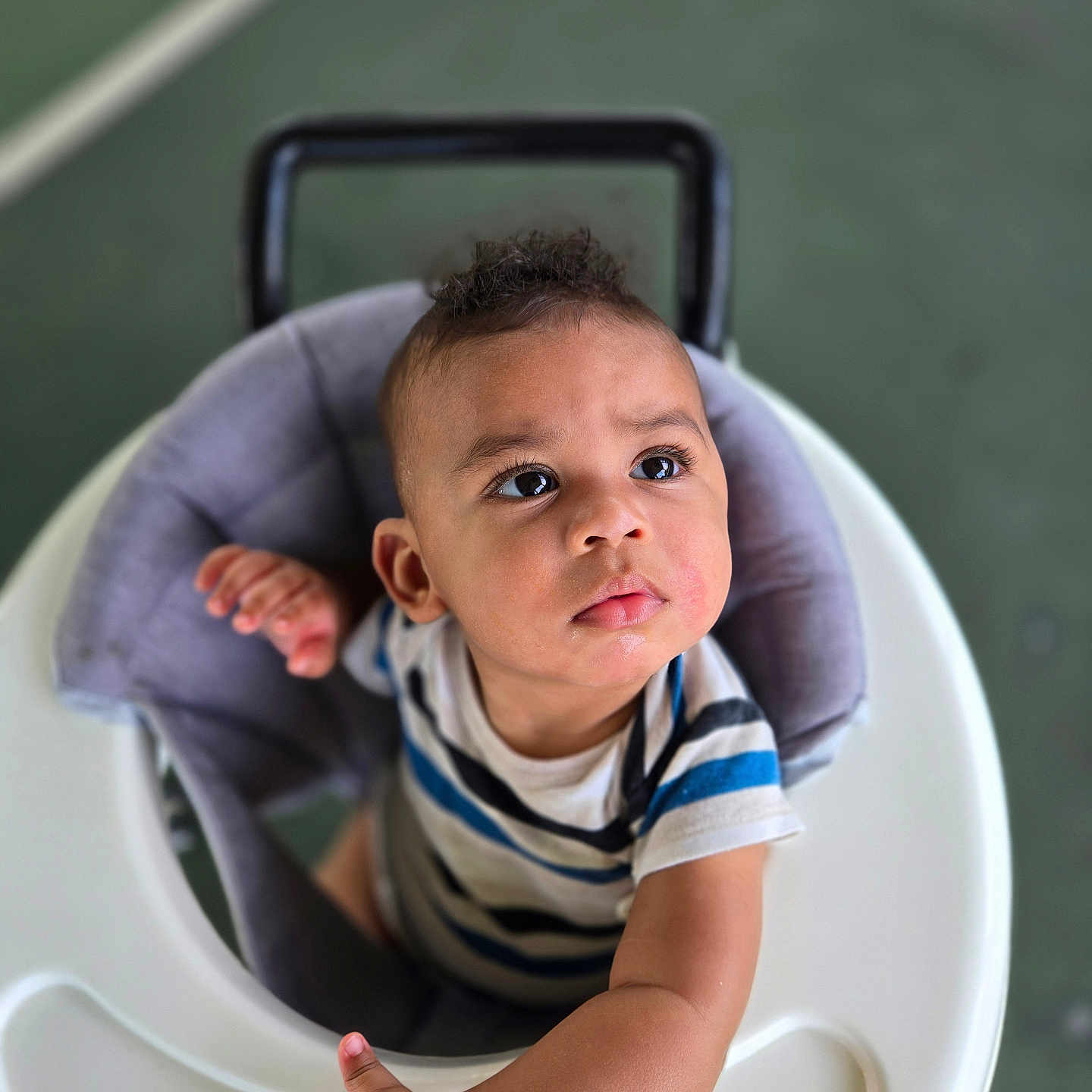 Zayden joined the competition — help win amazing prizes! arm, baby, child, closeup, curious, expression, face, floor, hand, indoor, infant, looking_up, person, play, seat, striped_shirt, toddler, toy, walker, young_child