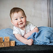 Lyam participe au concours pour gagner de l'argent avec cette photo : baby, infant, blue_blanket, wooden_blocks, smiling, face, white_shirt, cute, portrait, lying_down, soft_texture, indoors, child, happy, blue_eyes, skin, cheeks, blanket, toddler, closeup