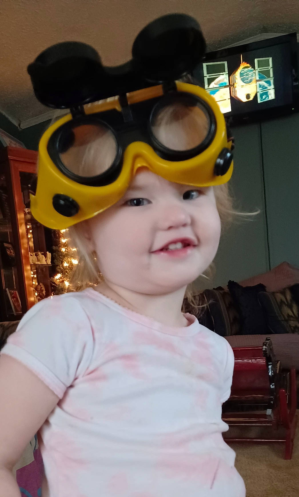 Harper is registered to the contest to win money with this photo: baby_toddler_clothing, child, costume, event, eyewear, fictional_character, fun, goggles, happy, headgear, headwear, helmet, mask, party, person, personal_protective_equipment, sports_equipment, sports_gear, t_shirt, toddler