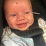 baby, smiling, car_seat, blanket, face, child, infant, close_up, seatbelt, cute, happy, skin, head, clothing, straps, indoors, human, person, mouth, teeth