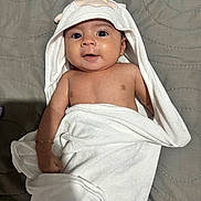 Mia Itzayana is registered to the contest to win money with this photo: baby, infant, towel, hooded_towel, cute, smiling, face, skin, arm, blanket, lying_down, indoors, child, person, fabric, soft, comfort, warm, expression, bed