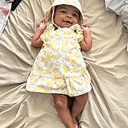 Journey joined the competition — help win amazing prizes! baby, infant, smiling, lying_down, dress, bonnet, bed, blanket, skin, happy, child, cute, pattern, fabric, person, indoors, small_hands, foot, comfort, relaxed