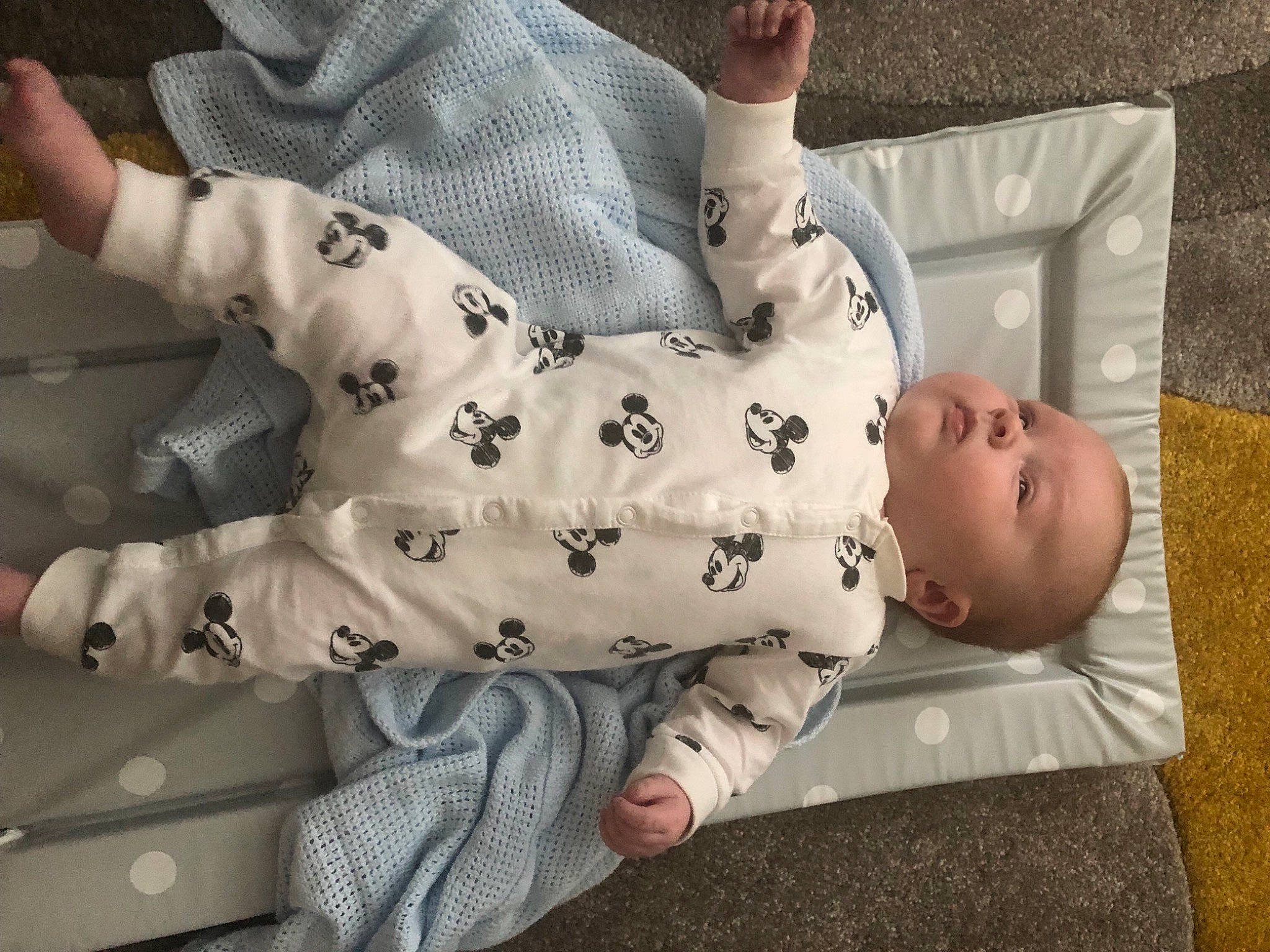 Kian is registered to the contest to win money with this photo: baby, baby_products, baby_toddler_clothing, barefoot, child, comfort, elbow, flooring, foot, knee, linens, nightwear, pattern, person, room, sitting, sleeve, sock, thigh, toddler
