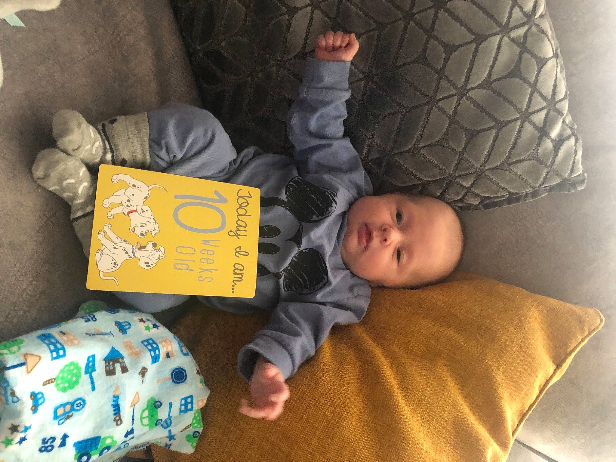 Kian is registered to the contest to win money with this photo: automotive_tire, baby, baby_toddler_clothing, bed, bedtime, child, comfort, finger, flooring, fun, human_body, leg, linens, nap, person, play, room, sitting, sleep, toddler