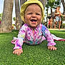 baby, child, smiling, crawling, grass, outdoor, sunhat, tie_dye_clothing, palm_trees, people, summer, vacation, happy, nature, family, playful, sunny, blue_sky, greenery, daytime