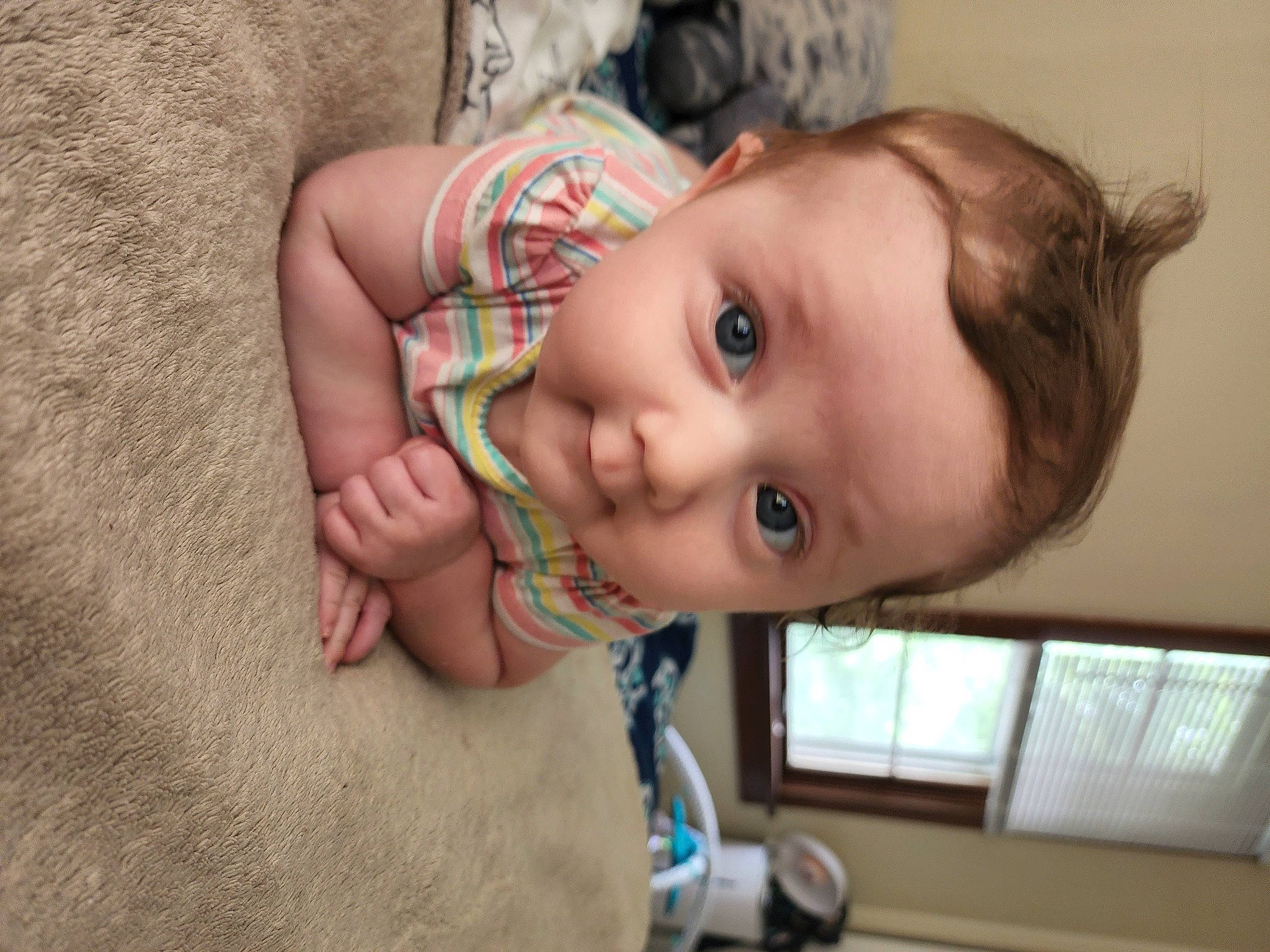 Elara is registered to the contest to win money with this photo: baby, baby_toddler_clothing, brown_hair, cheek, chest, child, ear, eyelash, fun, happy, human_body, lip, nose, person, room, skin, smile, thumb, toddler, window