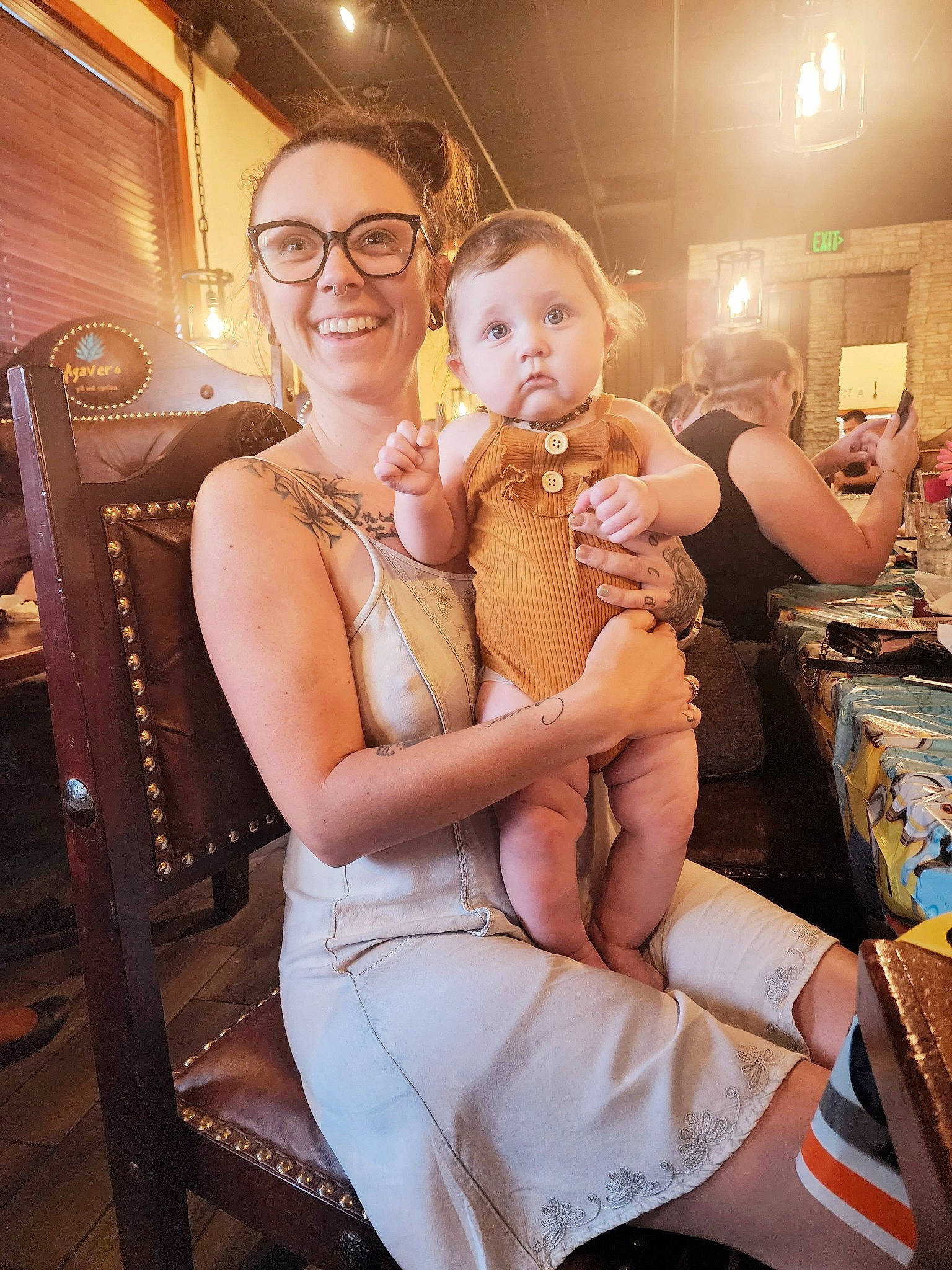 Elara is registered to the contest to win money with this photo: abdomen, baby, chair, dress, event, eyewear, fashion_design, fun, glasses, hairstyle, happy, joy, leisure, lighting, muscle, person, skin, smile, table, thigh