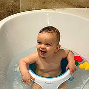 Paul a rejoint le concours — aidez-le/la à gagner de superbes lots ! baby, bathtub, bath_seat, water, smiling, child, bathroom, toy, splashing, skin, wet, happy, infant, seat, blue, white, yellow, red, green, tile
