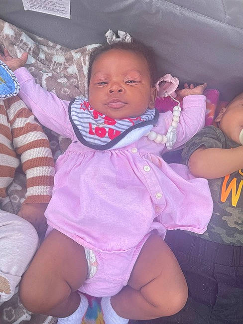 Kariyah is registered to the contest to win money with this photo: baby, baby_toddler_clothing, comfort, finger, fun, gesture, happy, iris, lap, leg, magenta, mouth, person, pink, purple, skin, textile, thigh, thumb, toddler