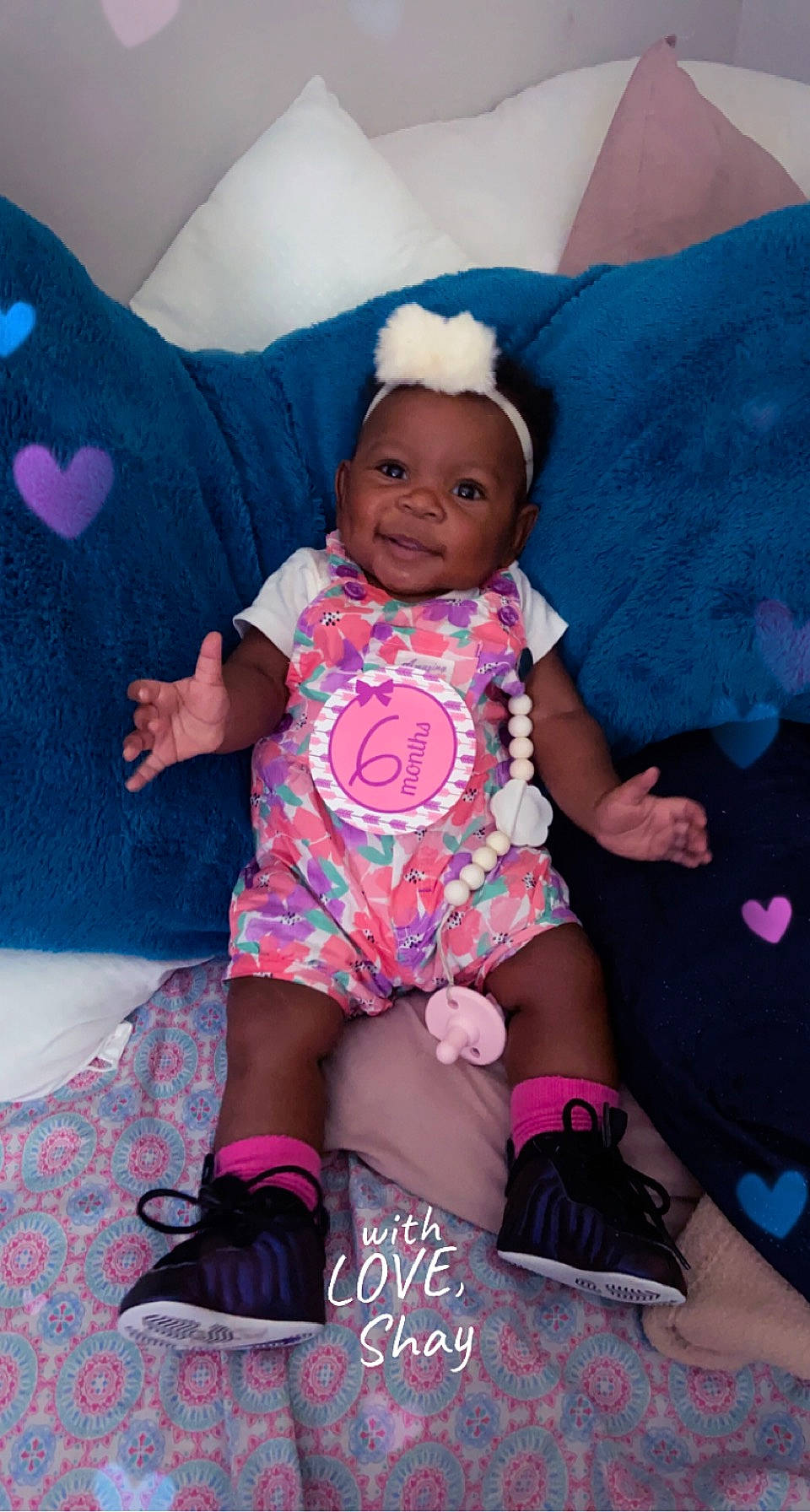 Kariyah is registered to the contest to win money with this photo: baby, baby_toddler_clothing, cheek, comfort, couch, finger, joy, leg, magenta, person, pink, product, purple, skin, sleeve, smile, sock, textile, thigh, toddler