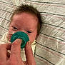 baby, bed, care, closeup, comfort, eyes, face, feeding_tube, hair, hand, health, human, infant, lying_down, newborn, pacifier, person, rest, skin, striped_blanket