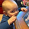 baby, child, infant, table, wood, chewing, hand, face, indoor, carpet, furniture, stroller, dolls, toy, curious, crawling, blue_clothing, closeup, person, cute