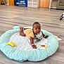 Liberty joined the competition — help win amazing prizes! baby, child, play_mat, floor, indoor, plush_toy, curious, clothing, bib, bracelet, wooden_floor, storage_shelves, cabinet, door, furniture, room, person, infant, cute, soft