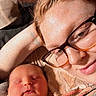 newborn, baby, person, glasses, sleeping, cuddle, blanket, indoor, portrait, closeup, skin, face, hand, cozy, warm_light, wooden_background, resting, family, love, comfort