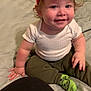 Adelio is registered to the contest to win money with this photo: baby, toddler, child, smiling, red_cap, spiderman, green_socks, bed, comforter, striped, white_shirt, pants, pregnant_belly, indoor, person, cute, happy, face, hand, sitting