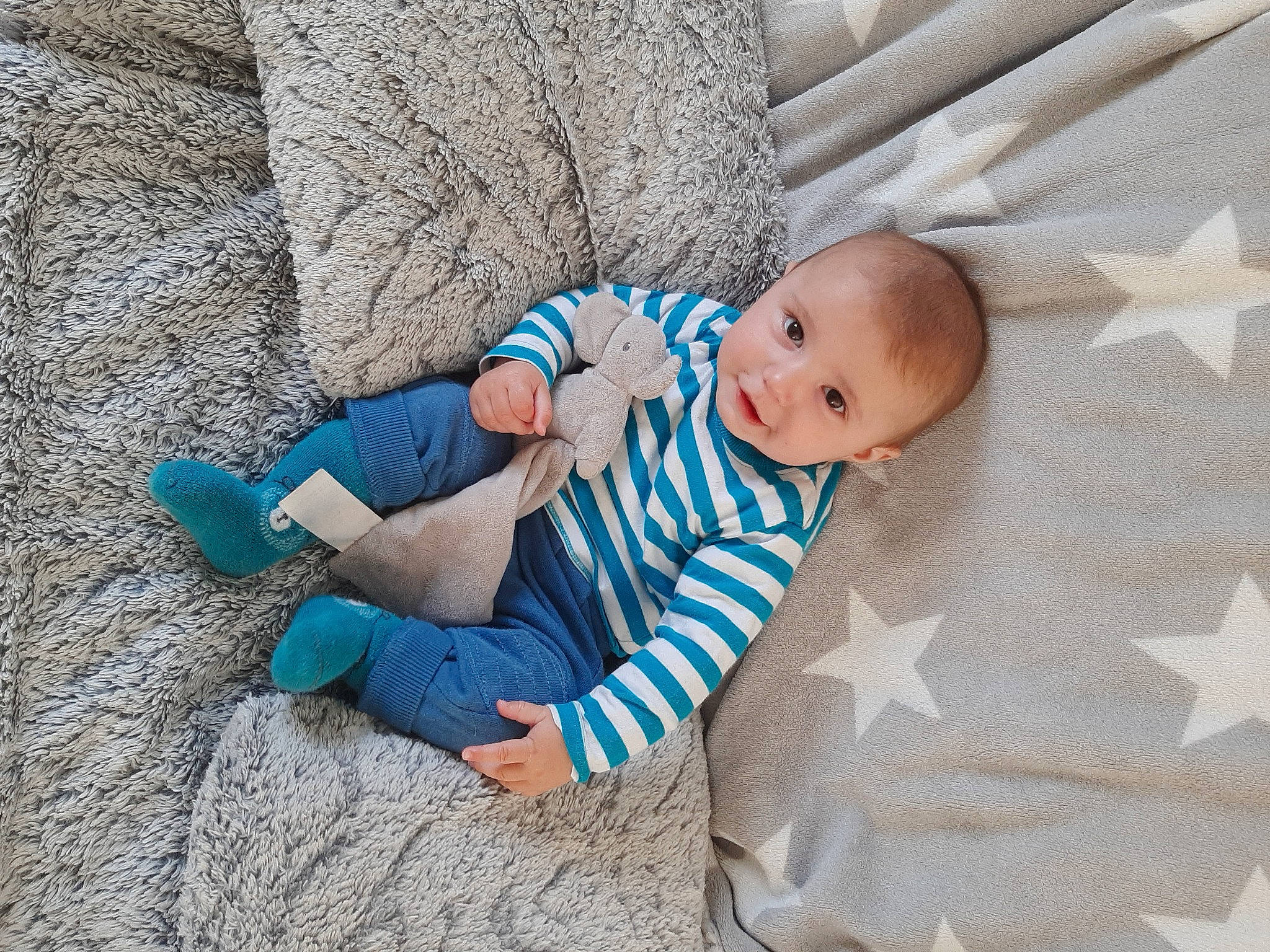 Ewenn participe au concours pour gagner de l'argent avec cette photo : baby, baby_products, baby_toddler_clothing, child, comfort, electric_blue, foot, grass, grey, leisure, linens, pattern, person, sitting, sock, t_shirt, toddler, tree, vacation, wood