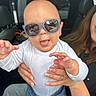 Noah joined the competition — help win amazing prizes! baby, child, infant, sunglasses, car, vehicle, portrait, indoors, sitting, standing, tongue_out, funny, smiling, white_shirt, blue_shorts, adult, hands, family, automotive, photography