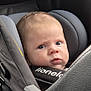 baby, child, car_seat, car_interior, seat_belt, gray_padding, infant, strapped_in, curious_expression, face, head, person, transportation, safety, young_child, car_trip, seat, baby_face, indoors, travel