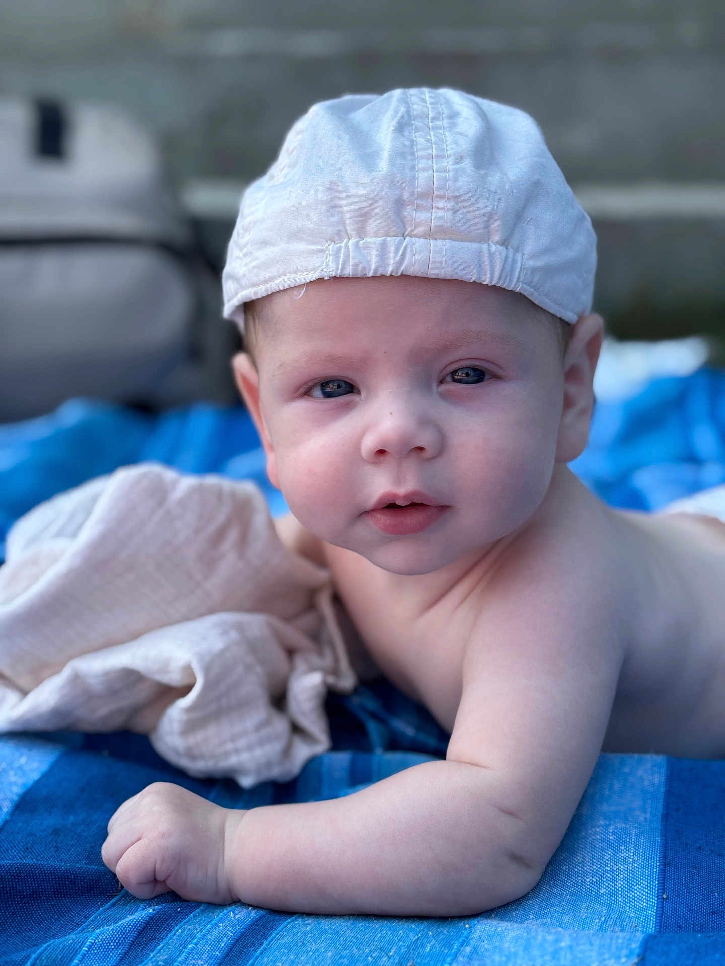Estebàn a rejoint le concours — aidez-le/la à gagner de superbes lots ! baby, child, cap, blue_blanket, skin, face, eyes, arm, hand, lying_down, infant, outdoor, soft_light, portrait, cute, expression, headwear, blanket, closeup, natural_light