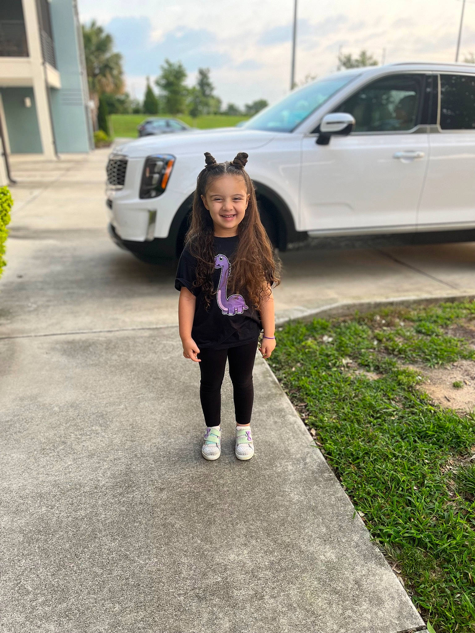 Nadia joined the competition — help win amazing prizes! alloy_wheel, asphalt, automotive_design, automotive_exterior, automotive_lighting, automotive_tire, bumper, car, grass, jeans, joy, land_vehicle, motor_vehicle, parking, person, plant, road_surface, tire, tree, vehicle