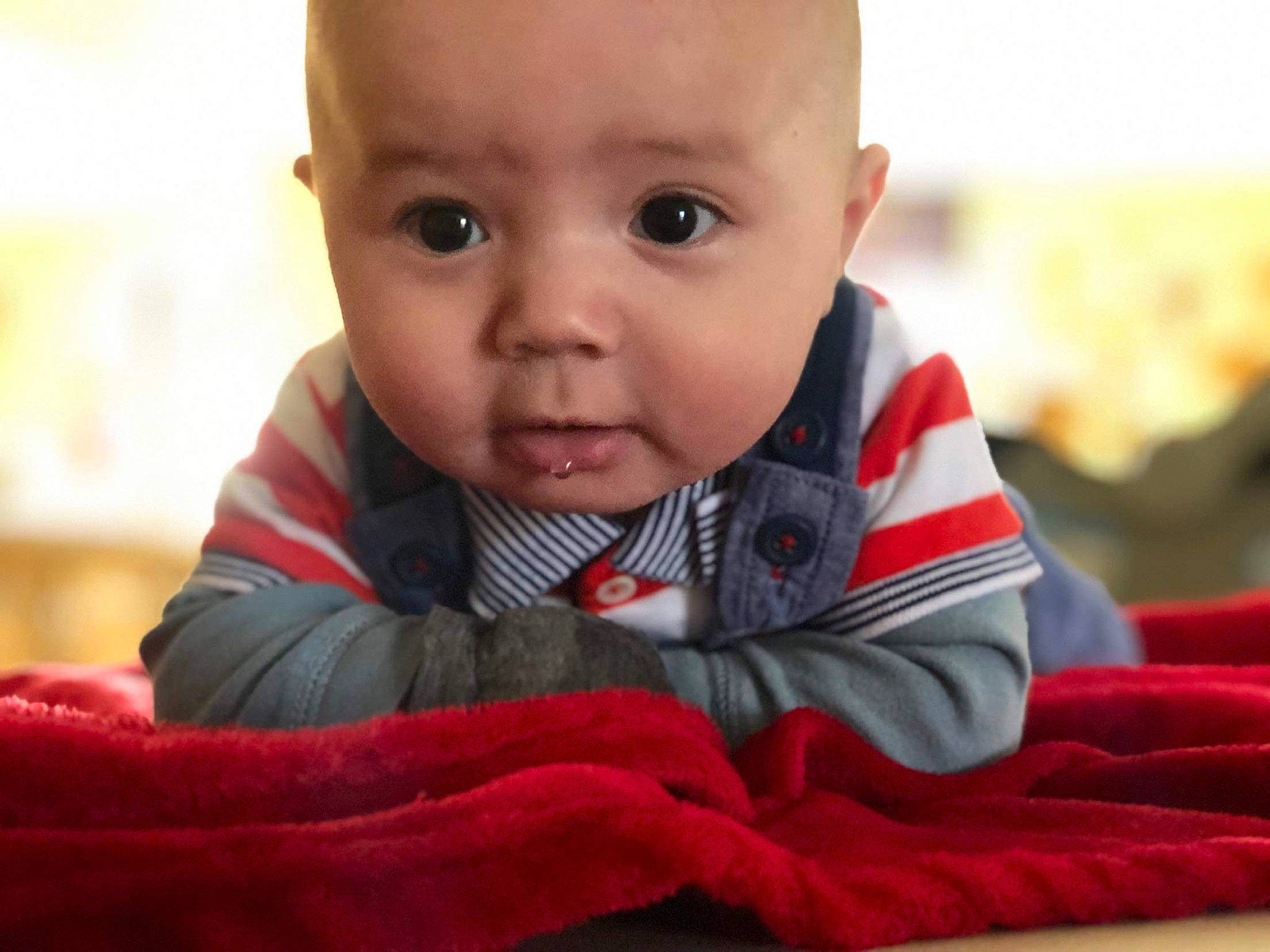 M-jay is registered to the contest to win money with this photo: baby, cheek, child, chin, electronic_device, eye, face, facial_expression, happy, head, lip, mouth, nose, person, play, sitting, skin, smile, toddler, tummy_time