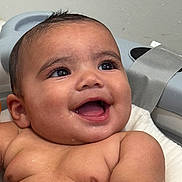 Saúl is registered to the contest to win money with this photo: baby, baby_bath_seat, bath, child, close_up, cute, expression, face, happy, indoors, infant, joy, person, skin, smiling, splash, strap, water, wet_skin, young_child