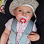 baby, infant, pacifier, car_seat, hat, blue_eyes, pink_clothing, safety_harness, child, cute, floral, seatbelt, closeup, portrait, indoor, small_hands, expression, headwear, comfort, care