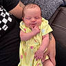 baby, infant, sleeping, yellow_dress, floral_pattern, tattoo, arm, couch, blanket, person, hand, skin, clothing, relaxation, comfort, portrait, indoor, cute, peaceful, child