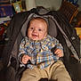 Braxton joined the competition — help win amazing prizes! baby, child, car_seat, plaid_shirt, beige_pants, smile, indoor, seat, infant, clothing, person, young_child, happy, cute, portrait, baby_clothes, sitting, head, face, hands