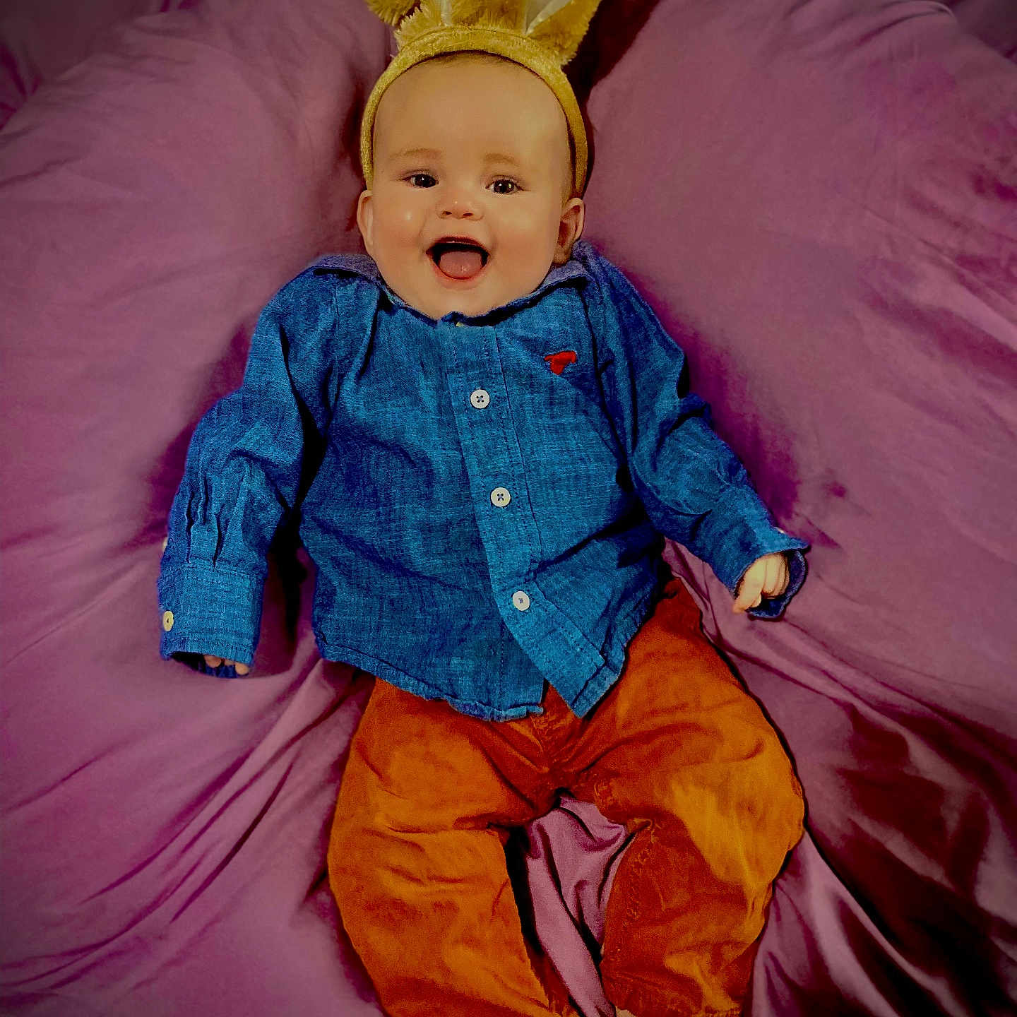 Michael is registered to the contest to win money with this photo: baby, babylaughing, bed, bedroom, clothing, coat, cushion, face, furniture, happy, head, homedecor, indoors, pants, person, photography, portrait, purple, room, sitting