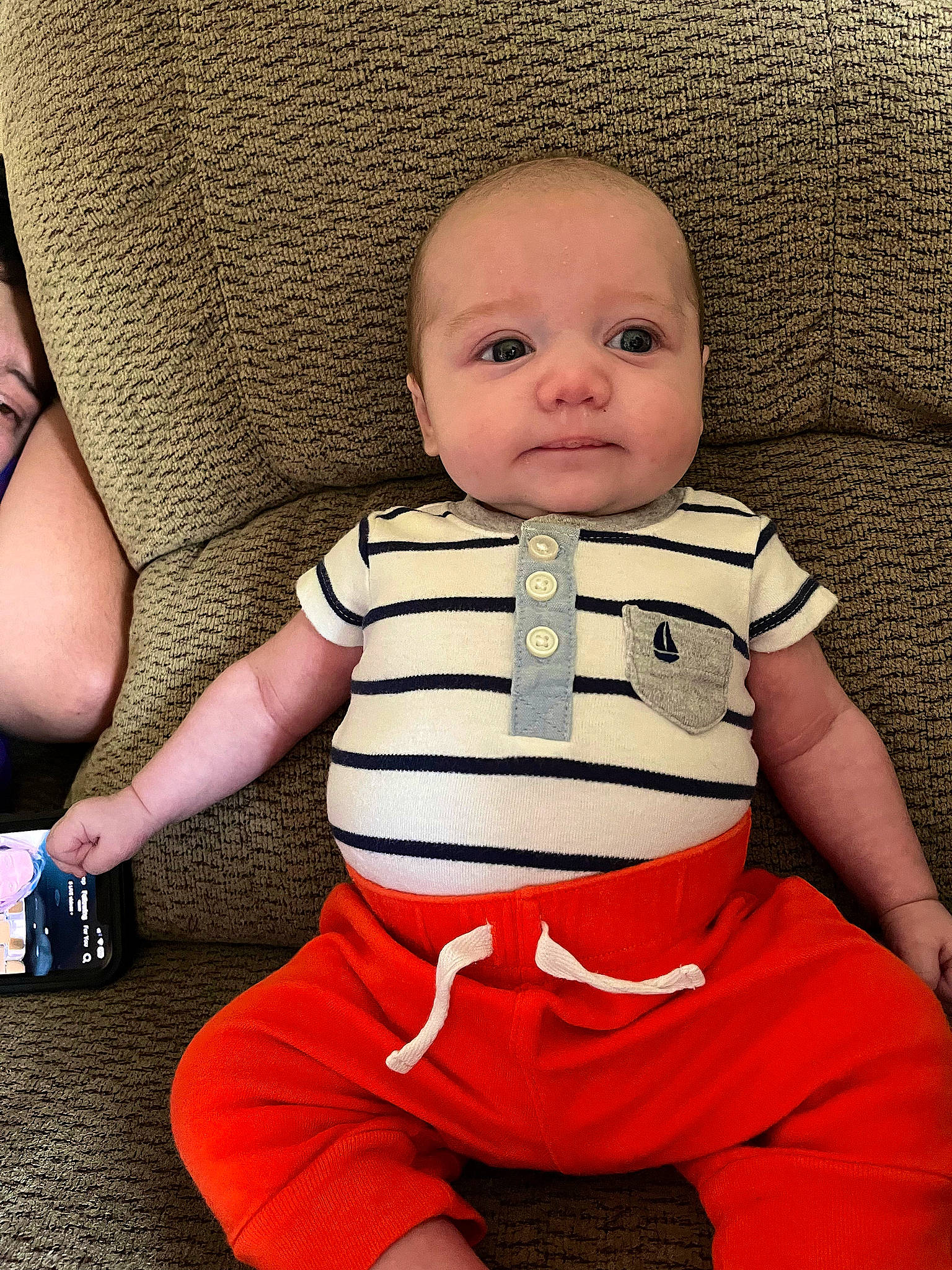 Blake is registered to the contest to win money with this photo: baby, baby_toddler_clothing, cheek, child, comfort, facial_expression, flooring, gesture, happy, human_leg, knee, pattern, person, sitting, skin, sleeve, thumb, toddler