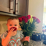 Averie is registered to the contest to win money with this photo: toddler, child, rose_petal, flower, bouquet, kitchen, countertop, cabinet, smile, happy, sitting, indoor, person, shirt, colorful, heart_design, plant, greenery, playful, portrait
