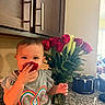 toddler, child, rose_petal, flower, bouquet, kitchen, countertop, cabinet, smile, happy, sitting, indoor, person, shirt, colorful, heart_design, plant, greenery, playful, portrait