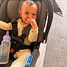 baby, baby_bottle, car_seat, child, clothing, comfort, cute, expression, face, hand, indoor, infant, pacifier, person, safety, seatbelt, sitting, soft_lighting, toddlers, young