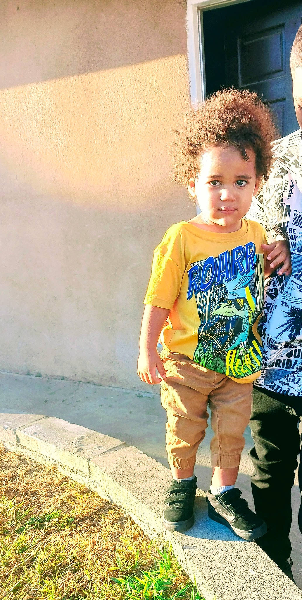 Destin is registered to the contest to win money with this photo: child, cool, denim, electric_blue, eyewear, fun, grass, happy, leisure, people_in_nature, person, play, shadow, shoulder, sitting, sleeve, t_shirt, tints_and_shades, toddler, top