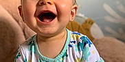Caleb participe au concours pour gagner de l'argent avec cette photo : toddler, child, smiling, happy, onesie, colorful_clothing, indoor, plush_toy, soft_toy, face, blue_wall, short_hair, cute, baby, person, portrait, closeup, joyful, playful, light